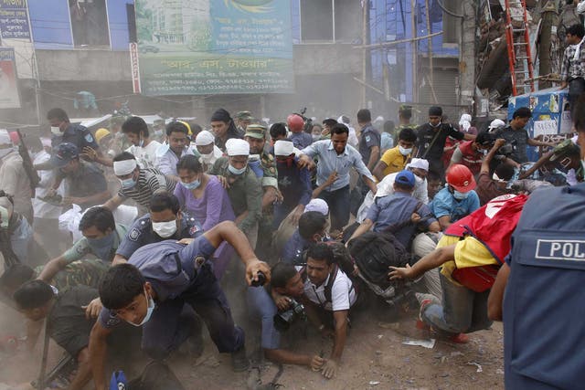 Rescue workers, army personnel, police and members of media run after they heard someone shouting that a building next to Rana Plaza is collapsing during a rescue operation in Savar