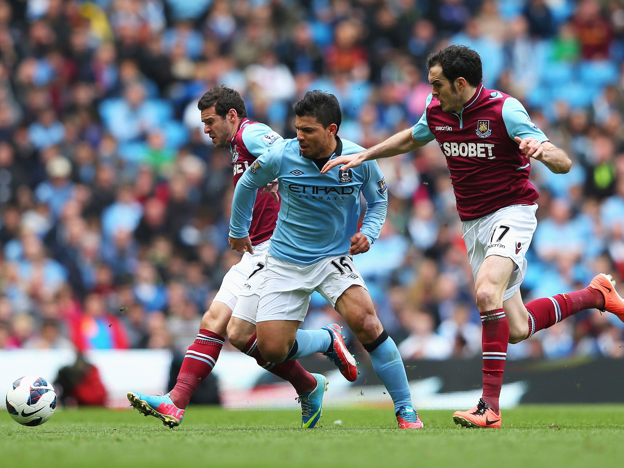 Sergio Aguero of Manchester City is challenged by Matt Jarvis (L) and Joey O'Brien of West Ham United