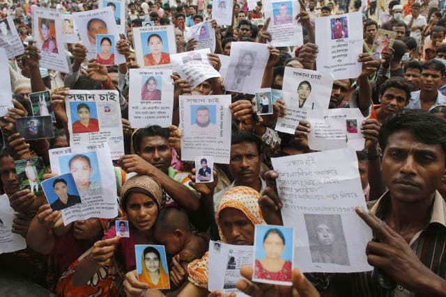 Worried relatives hold pictured of their loved ones, still missing after the Dhaka factory disaster