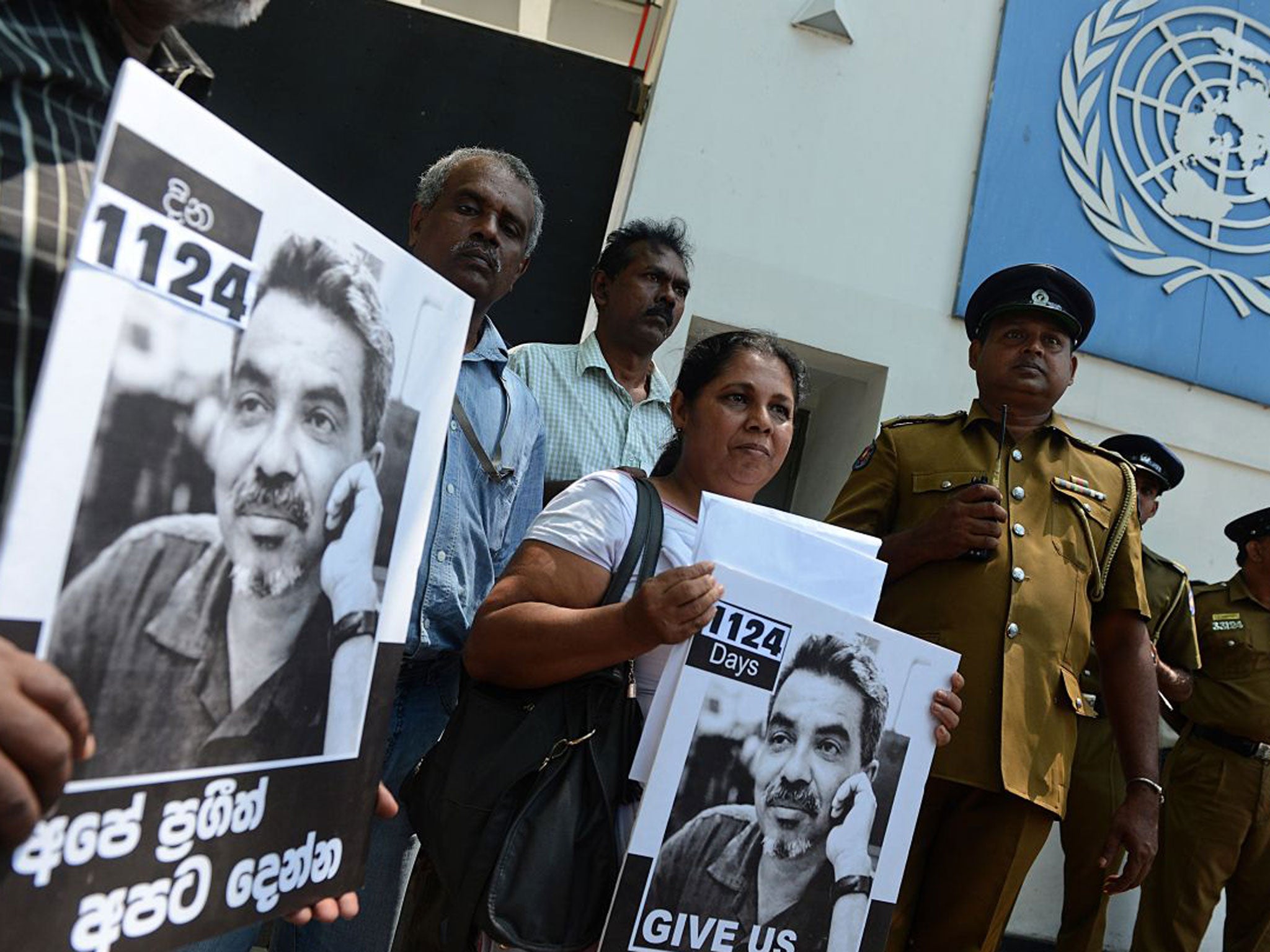 Sandhya Eknaligoda (C), wife of missing Sri Lankan cartoonist Prageeth Eknelygoda, holds a placard bearing his image outside the United Nations offices in Colombo on February 21, 2013. Eknaligoda urged UN intervention to locate her husband, missing since