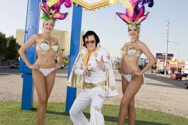 An Elvis impersonator posing in front of Las Vegas welcome sign, Nevada, USA