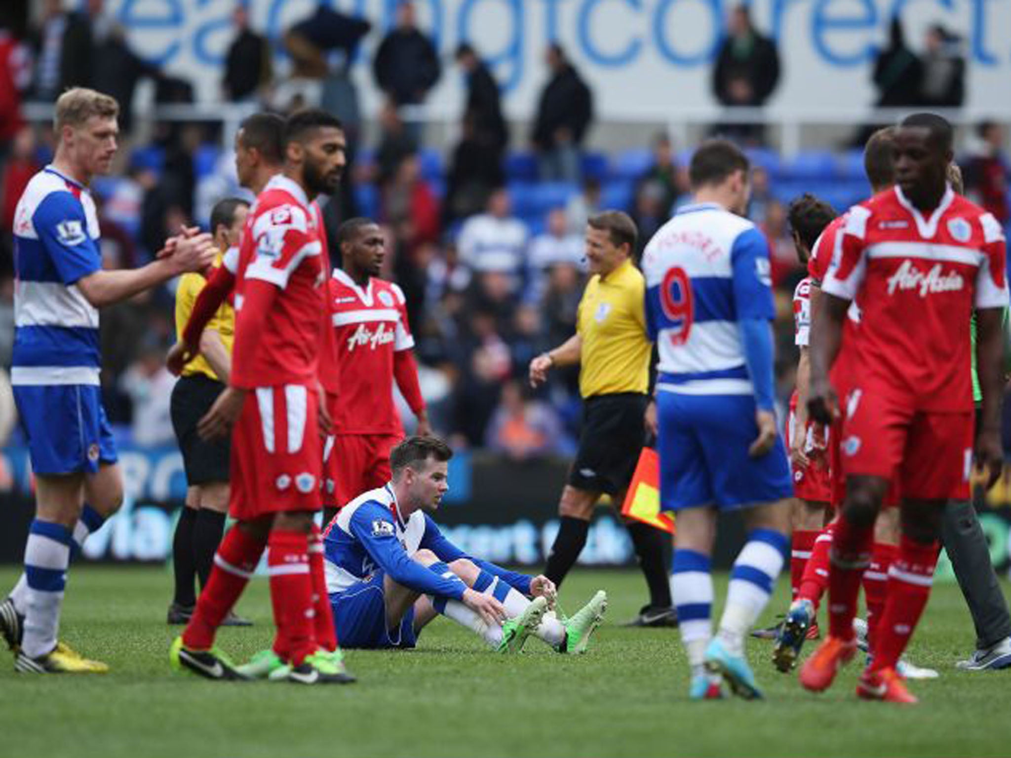 Danny Guthrie of Reading sits on the ground dejected as players from both teams shake hands after the final whistle (Getty Images)
