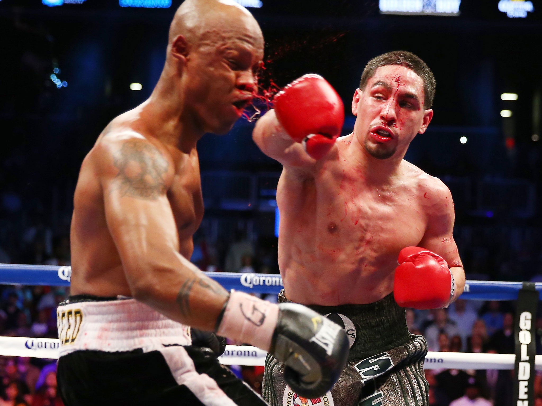 Danny Garcia, right, who could face Amir Khan in the future, lands a heavy blow on Zab Judah in their bloody light welterweight title clash