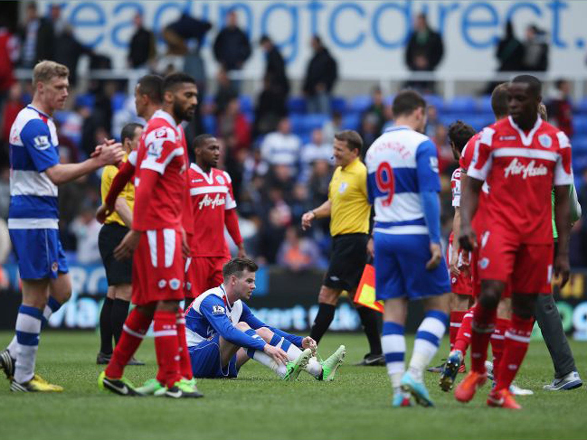 Danny Guthrie of Reading sits on the ground dejected after his team and QPR were relegated during the Barclays Premier League match between Reading and Queens Park Rangers at the Madejski Stadium