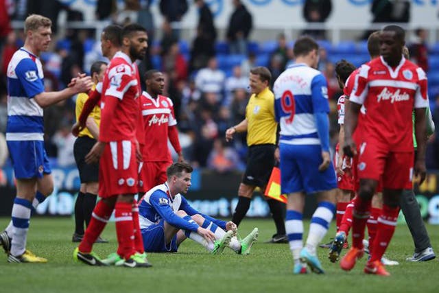 Danny Guthrie of Reading sits on the ground dejected after his team and QPR were relegated during the Barclays Premier League match between Reading and Queens Park Rangers at the Madejski Stadium