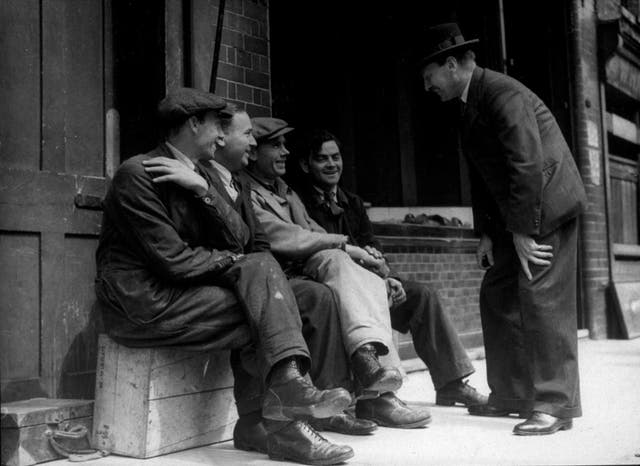 Leader of the Labour Party Clement Attlee chatting with workers during a tour of his constituency in 1944