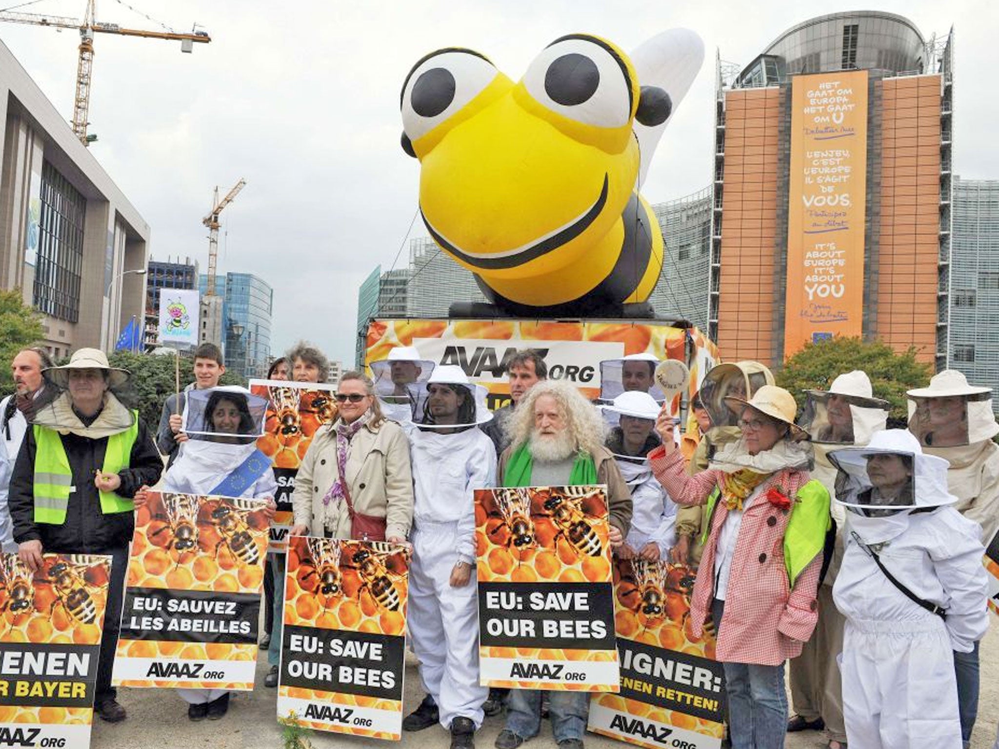 Beekeepers, with a five metre inflatable bee, demonstrate at the EU headquarters' doors in Brussels to confront lawmakers as they decide to vote on whether to ban bee-killing pesticides