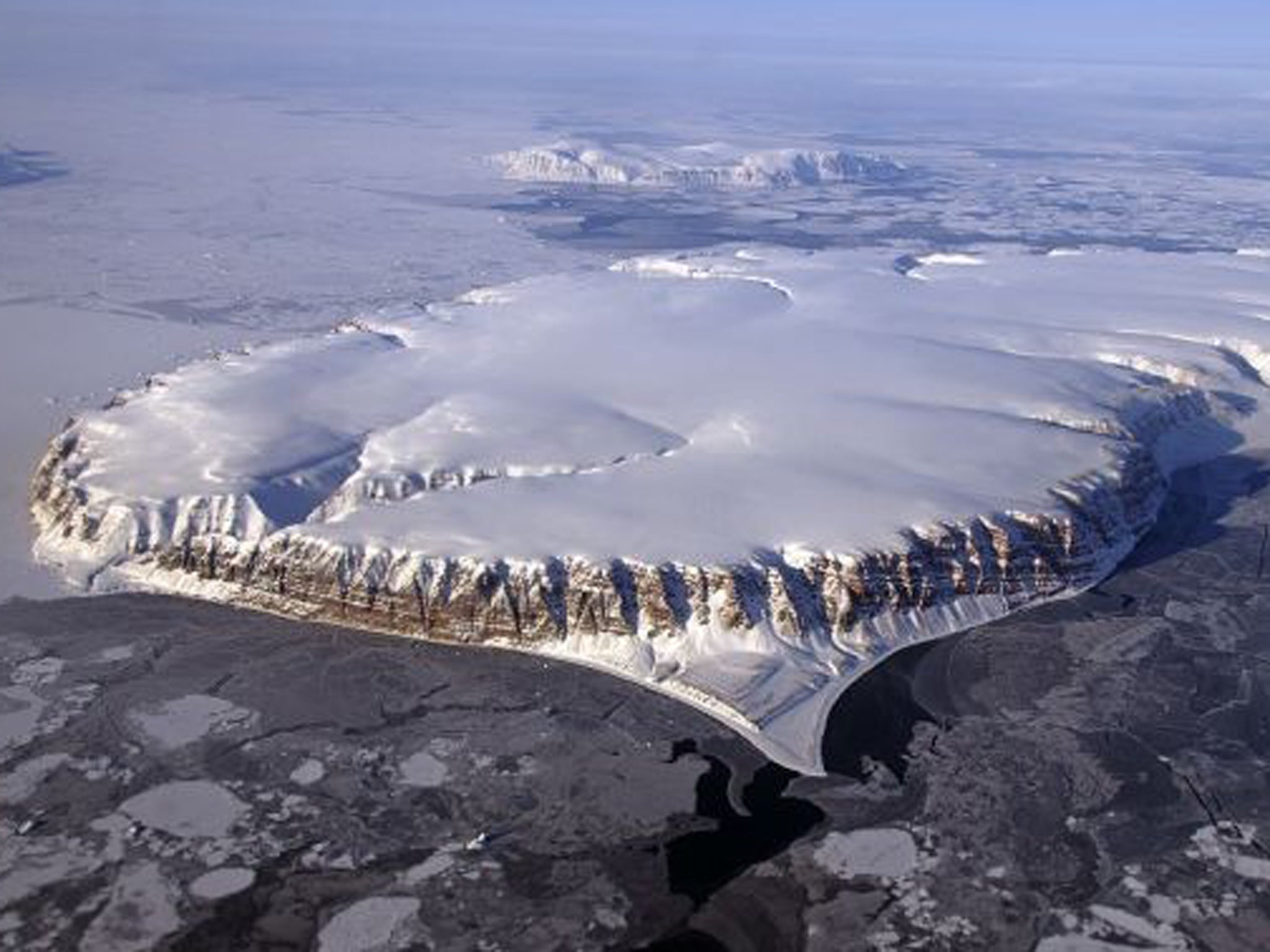 This Nasa image from 20 April 2013 shows Saunders Island and Wolstenholme Fjord with Kap Atholl in the background seen during an IceBridge survey flight near Qaasuitsup, Greenland