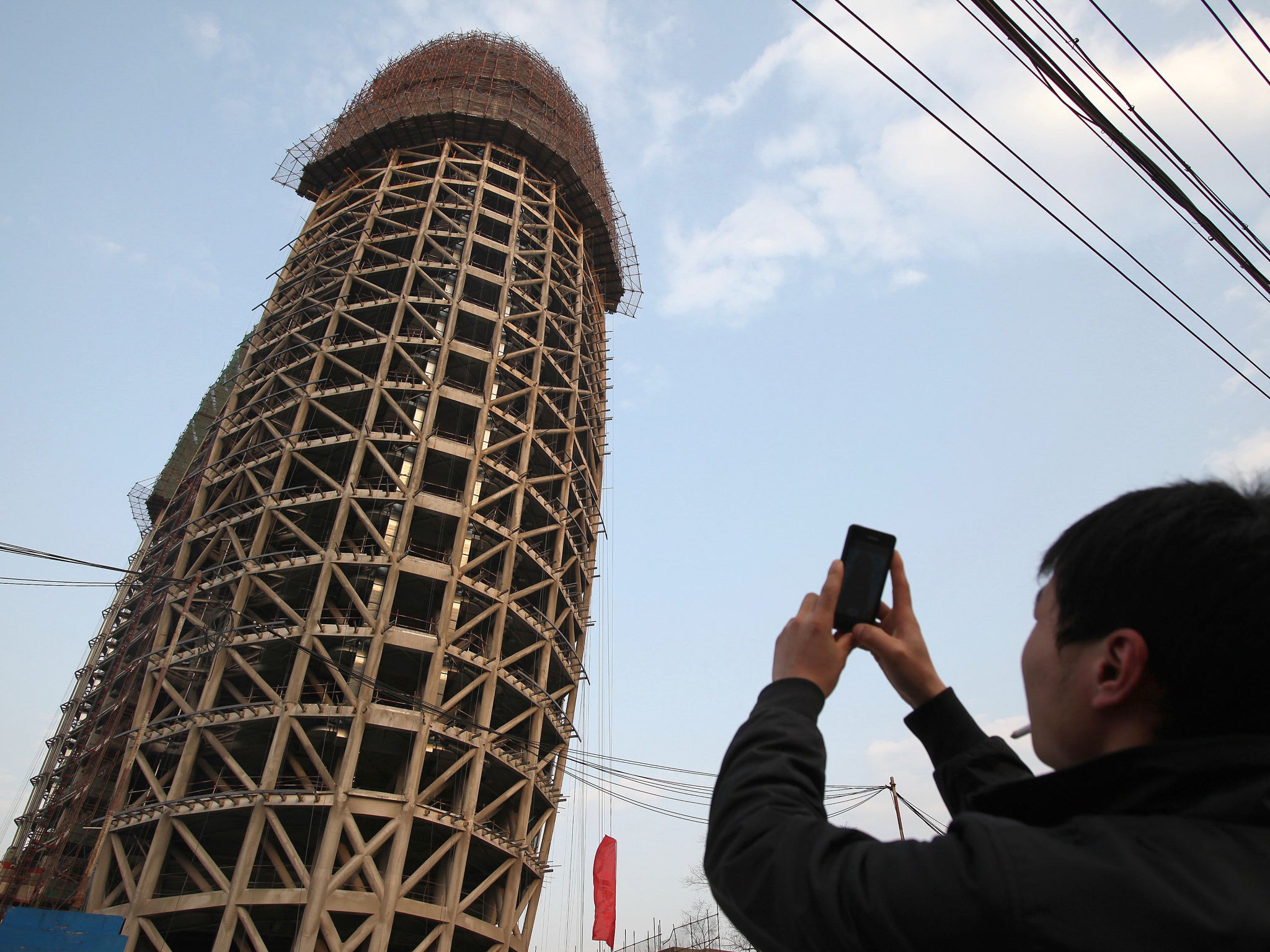 A man in China takes a photograph of the People's Daily's new headquarters
