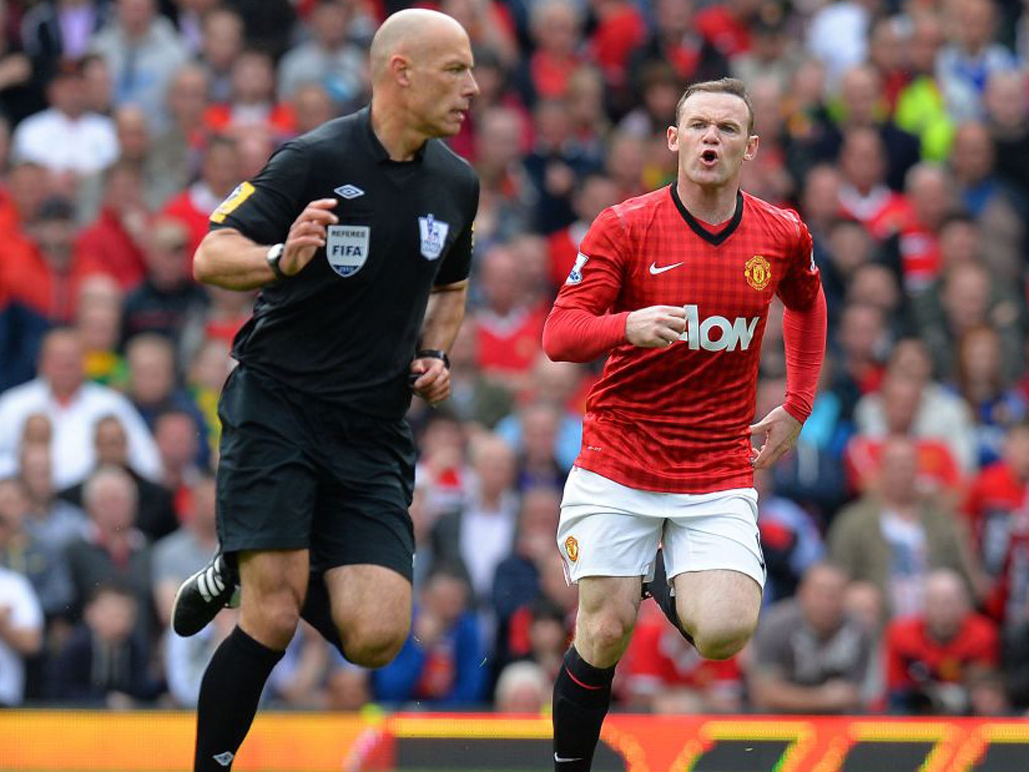 Wayne Rooney discusses the finer points of the game with Howard Webb
