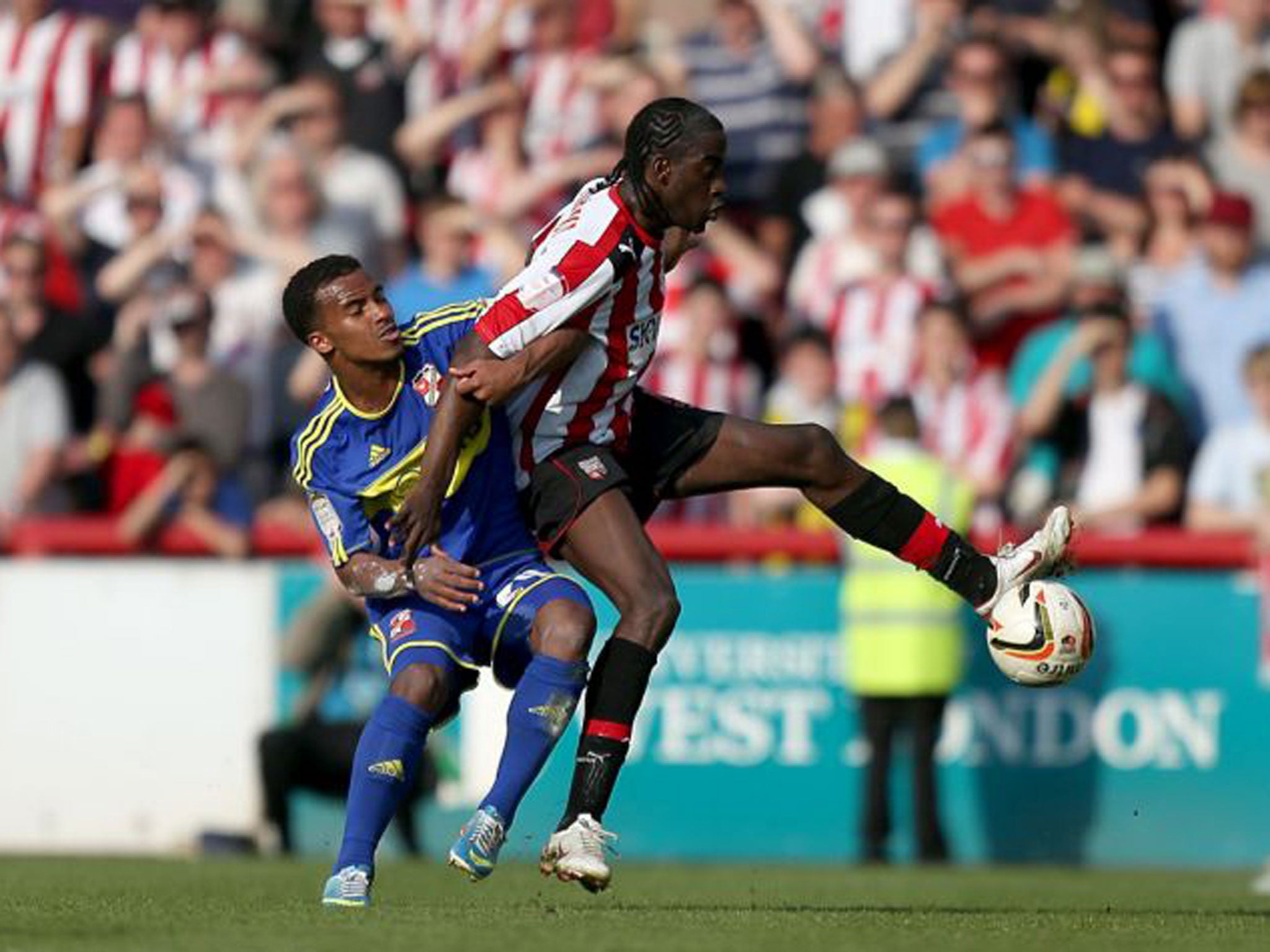 Swindon Town's Nathan Byrne, left, battles for the ball with Brentford's Clayton Donaldson during the npower Football League One Play Off Semi-final, Second Leg match at Griffin Park, Brentford
