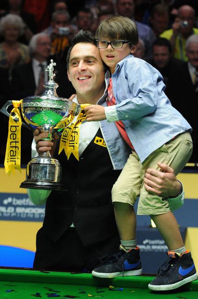 Ronnie O’Sullivan and his son, Ronnie, hold the winner’s trophy aloft last night