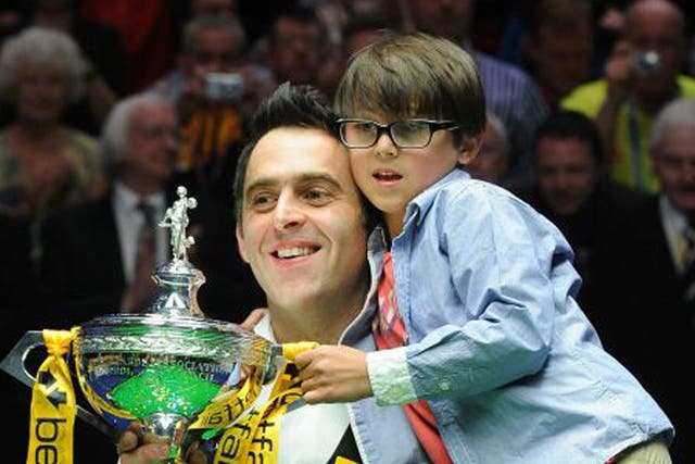Ronnie O’Sullivan and his son, Ronnie, hold the winner’s trophy aloft last night