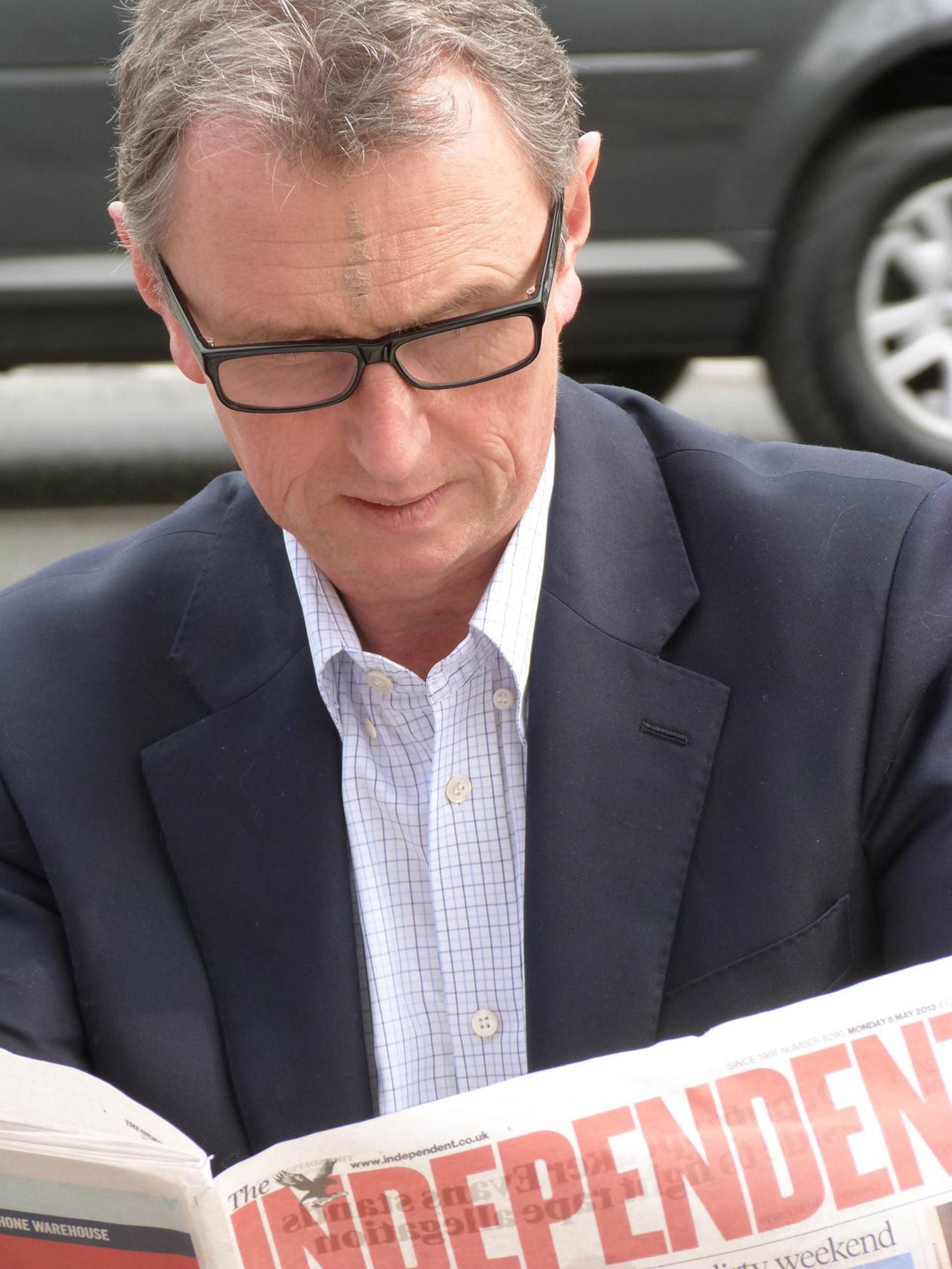 Nigel Evans, pictured yesterday with the bruise on his head, reading a copy of The Independent
