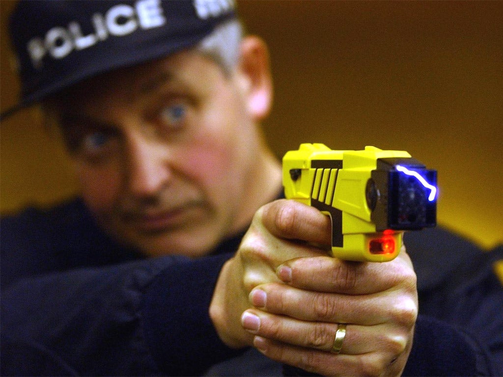 A policeman fires a Taser gun.