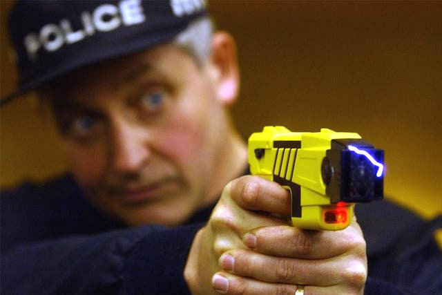 A policeman fires a Taser gun.