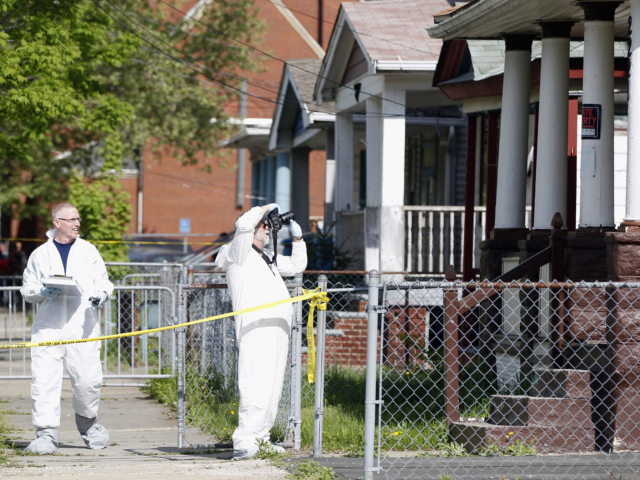 Police in protective suits investigate houses down the street from the house where three women were held captive for close to a decade May 8, 2013 in Cleveland, Ohio. Amanda Berry, Gina DeJesus, and Michelle Knight managed to escape their captors on May 6, 2013. Ariel Castro was charged with kidnap and rape. His brother Pedro and Onil Castro, were taken into custody but not charged.