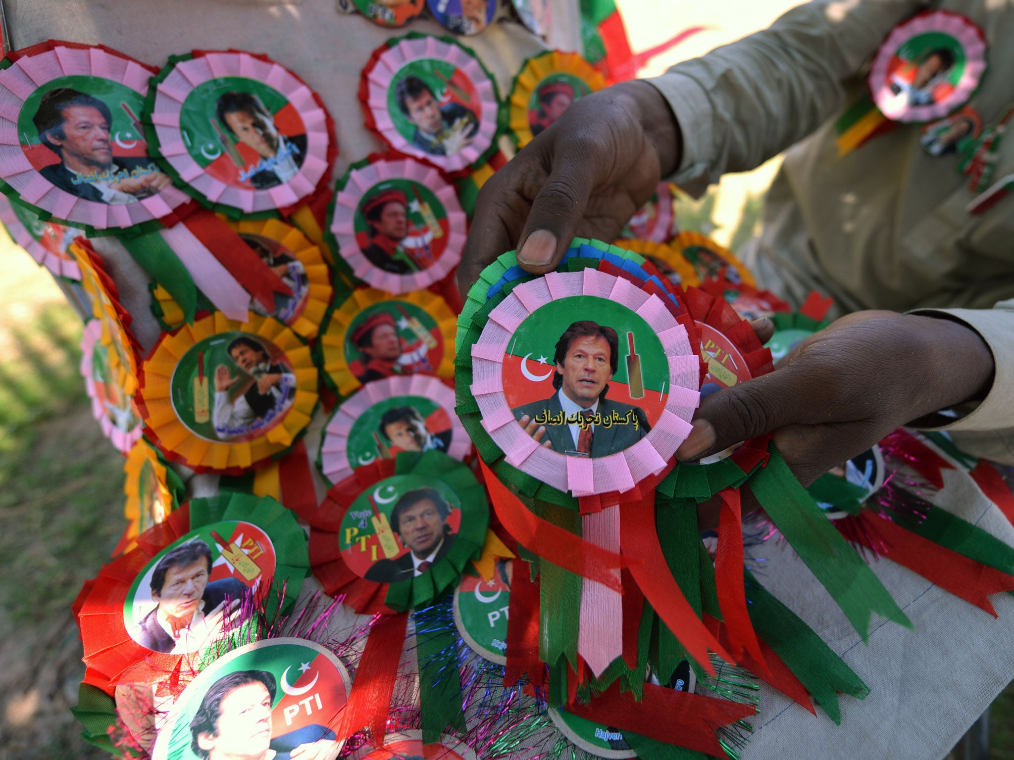 A Pakistani vendor arranges badges of Pakistani politician and former cricketer Imran Khan at the venue of an election campaign meeting by Khan's party Pakistan Tehreek-e-Insaf (PTI) in Islamabad on May 9, 2013.