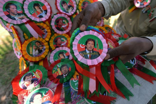 A Pakistani vendor arranges badges of Pakistani politician and former cricketer Imran Khan at the venue of an election campaign meeting by Khan's party Pakistan Tehreek-e-Insaf (PTI) in Islamabad on May 9, 2013.
