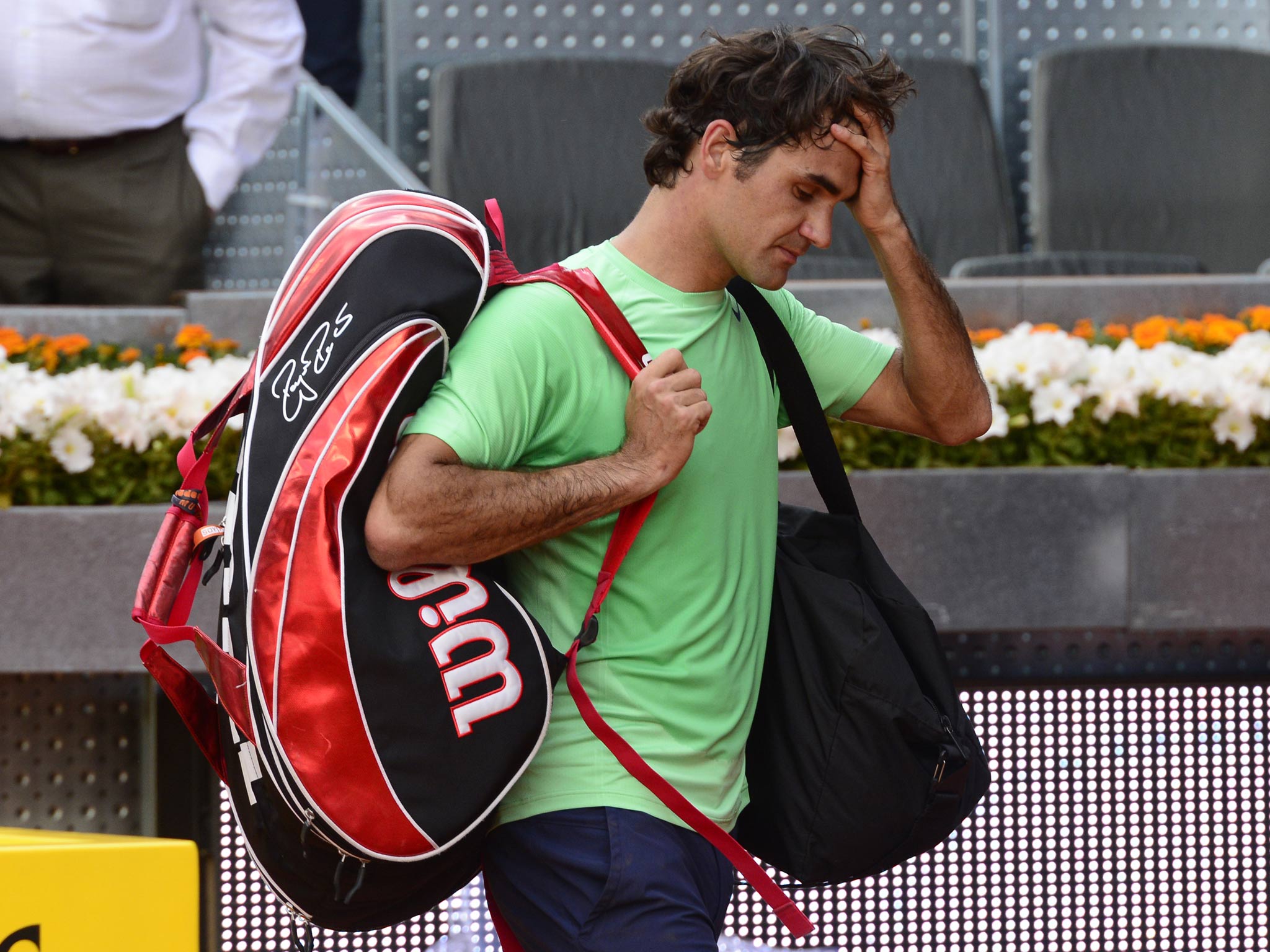Roger Federer leaves the court after being stunned by Japan's Kei Nishikori in the last 16 of the Madrid Masters