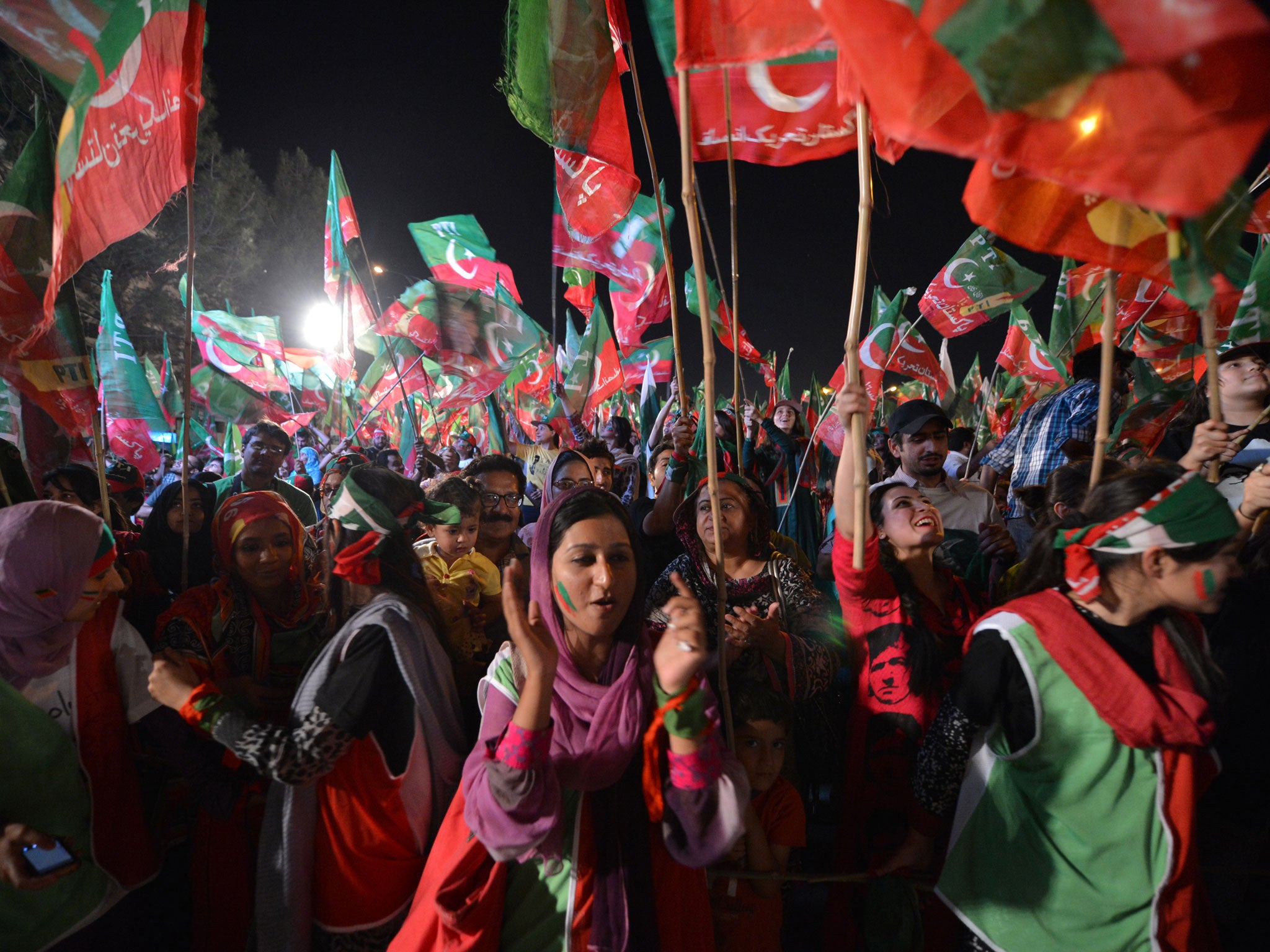 Supporters of Pakistani politician and former cricketer Imran Khan cheer as they wait to listen Khan video link address from a hospital during his last election campaign meeting in Islamabad on May 9, 2013.