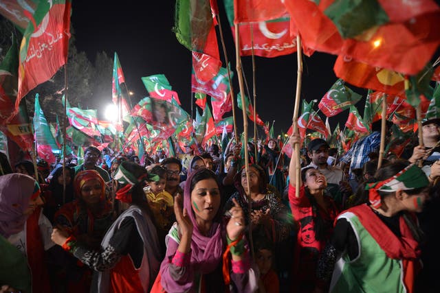 Supporters of Pakistani politician and former cricketer Imran Khan cheer as they wait to listen Khan video link address from a hospital during his last election campaign meeting in Islamabad on May 9, 2013.