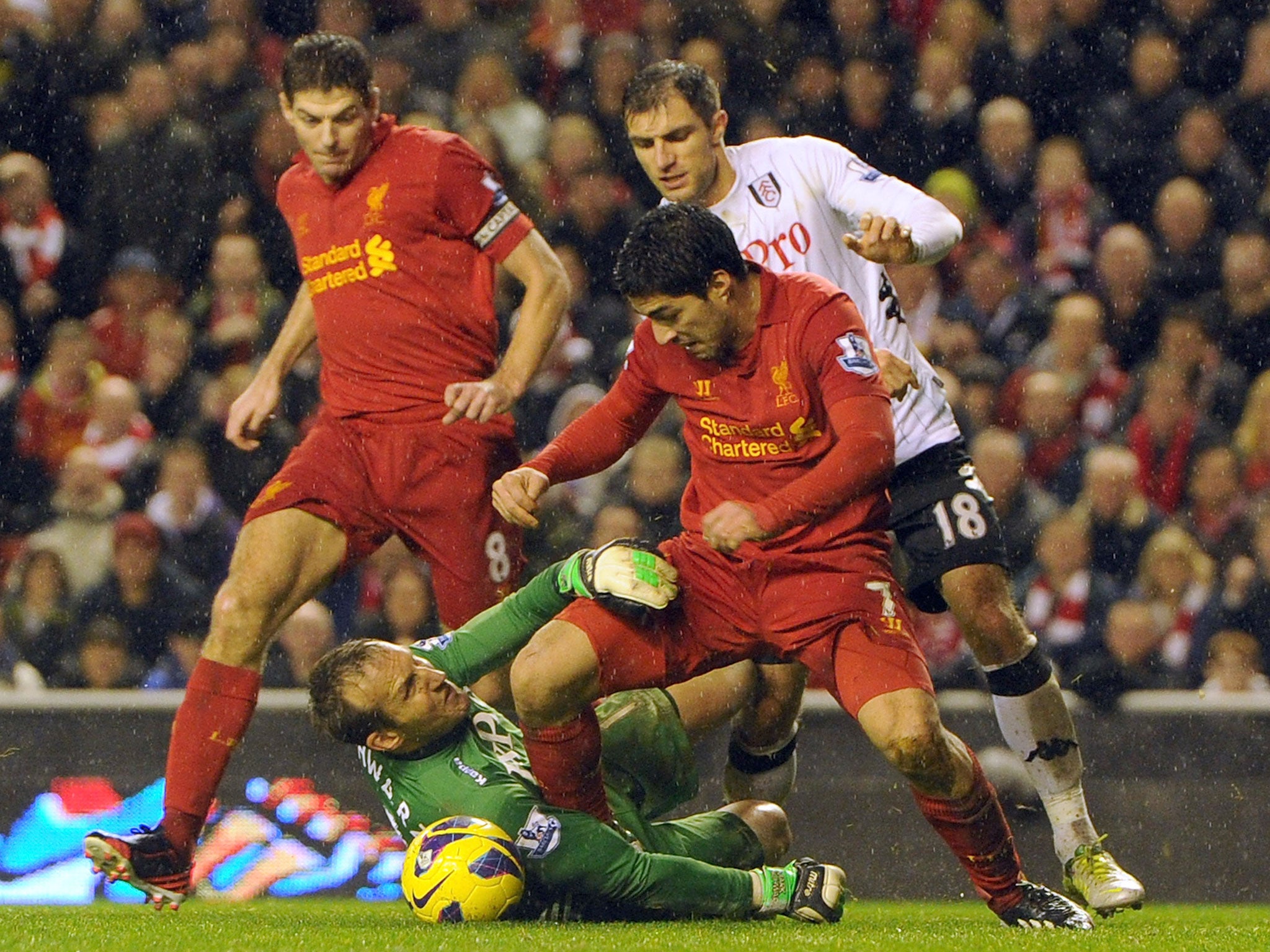Mark Schwarzer of Fulham and Luis Suarez of Liverpool compete