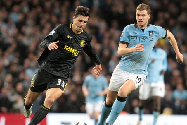 Manchester City's Bosnian striker Edin Dzeko (R) vies with Wigan Athletic's Austrian midfielder Paul Scharner