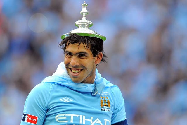 Carlos Tevez with the FA Cup trophy lid upon his head in 2011