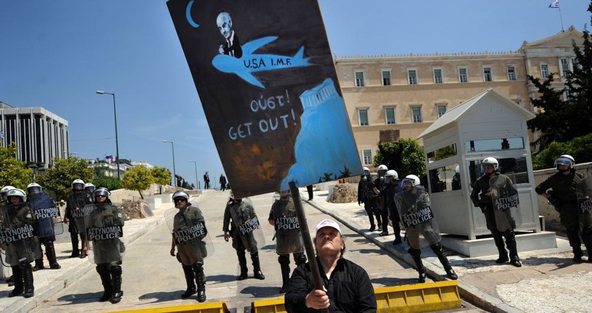 A protester is blocked in by police as he demonstrates against austerity measures in Greece