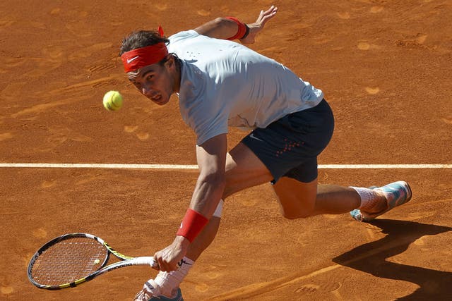 Rafael Nadal reaches to volley a return to David Ferrer