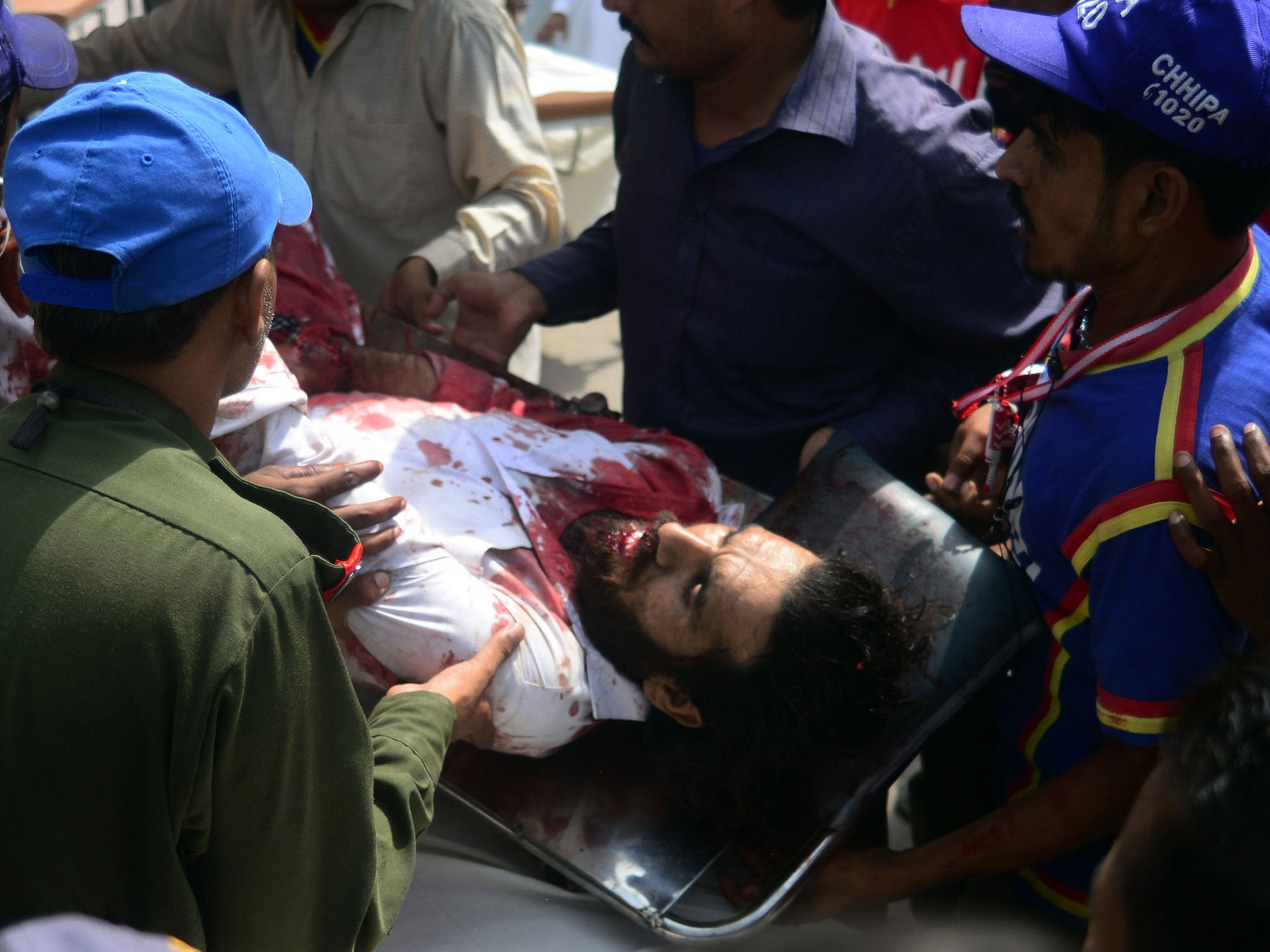 Pakistani volunteers carry an injured blast victim to a hospital following a bomb explosion in Karachi