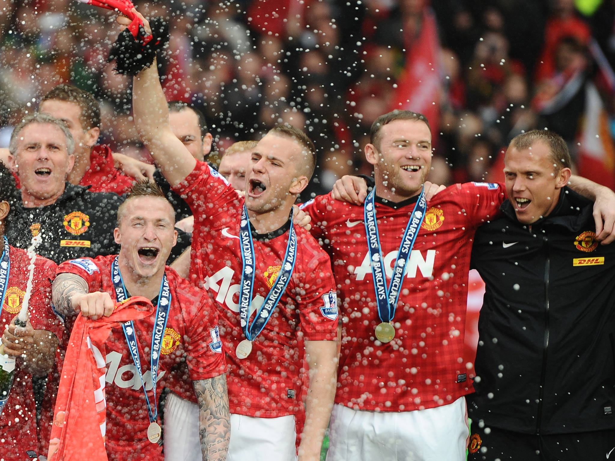 Wayne Rooney celebrates Manchester United's success with Alexander Buttner, and Tom Cleverley