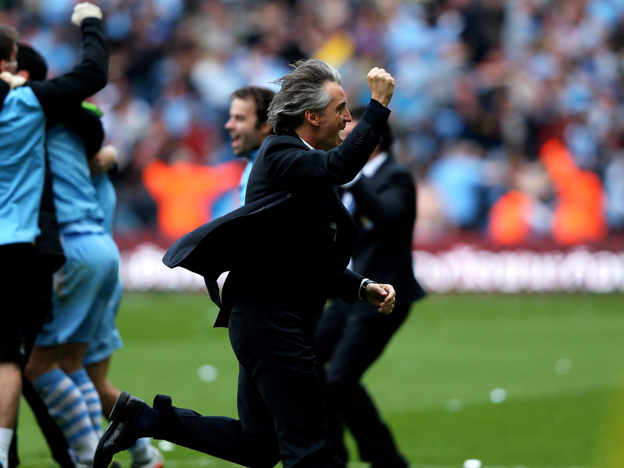 13 May 2012: Mancini runs onto the pitch at after the final whistle of a 3-2 win over Queen's Park Rangers celebrating Manchester City winning the Premier League title on goal difference over Manchester United (Alex Livesey/Getty Images)