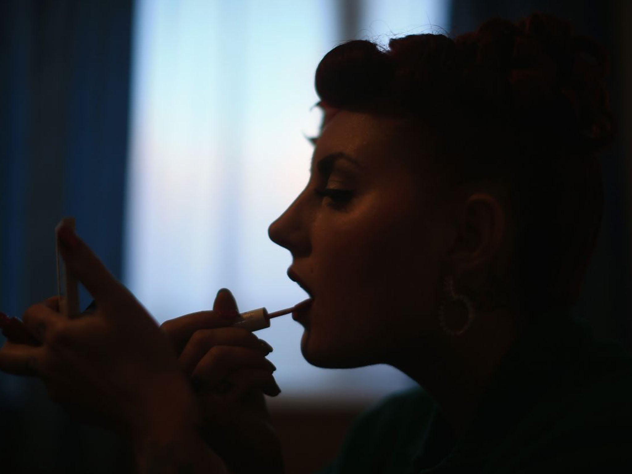 Rock 'n' Roll devotee Lori Barker puts on lipstick as she prepares to re-live the '40s and the '50s at the festival