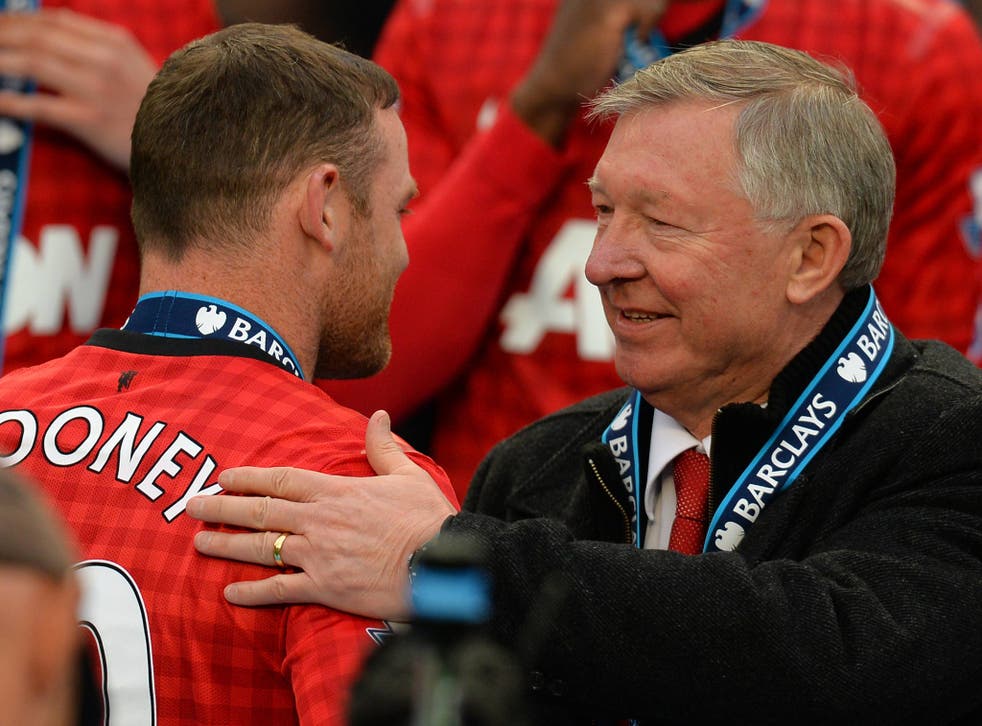Wayne Rooney receives a pat on the back from Sir Alex Ferguson as Manchester United are awarded the Premier League trophy