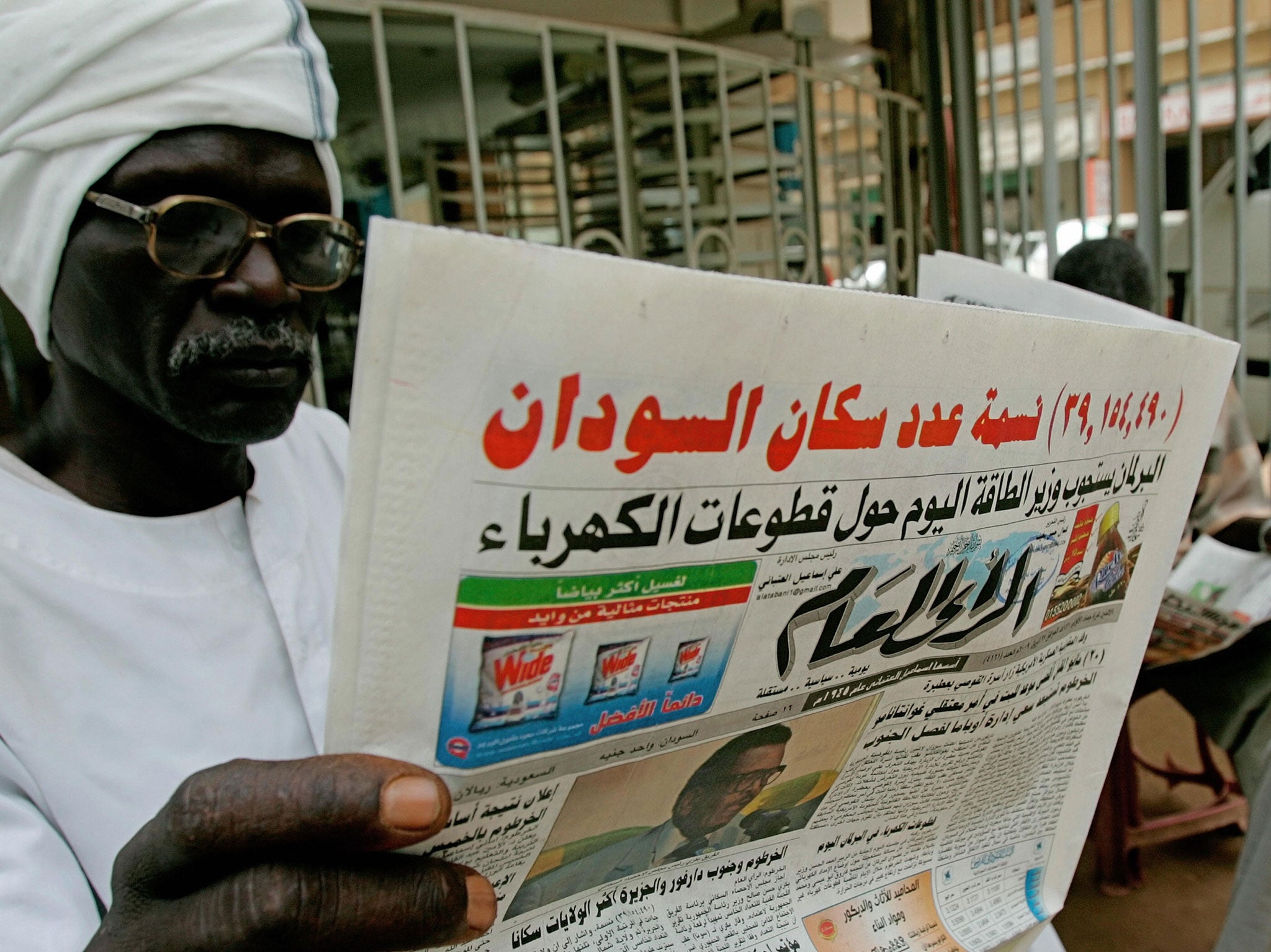 Sudanese men read local Arabic newspapers outside a shop in Khartoum on April 27, 2009.