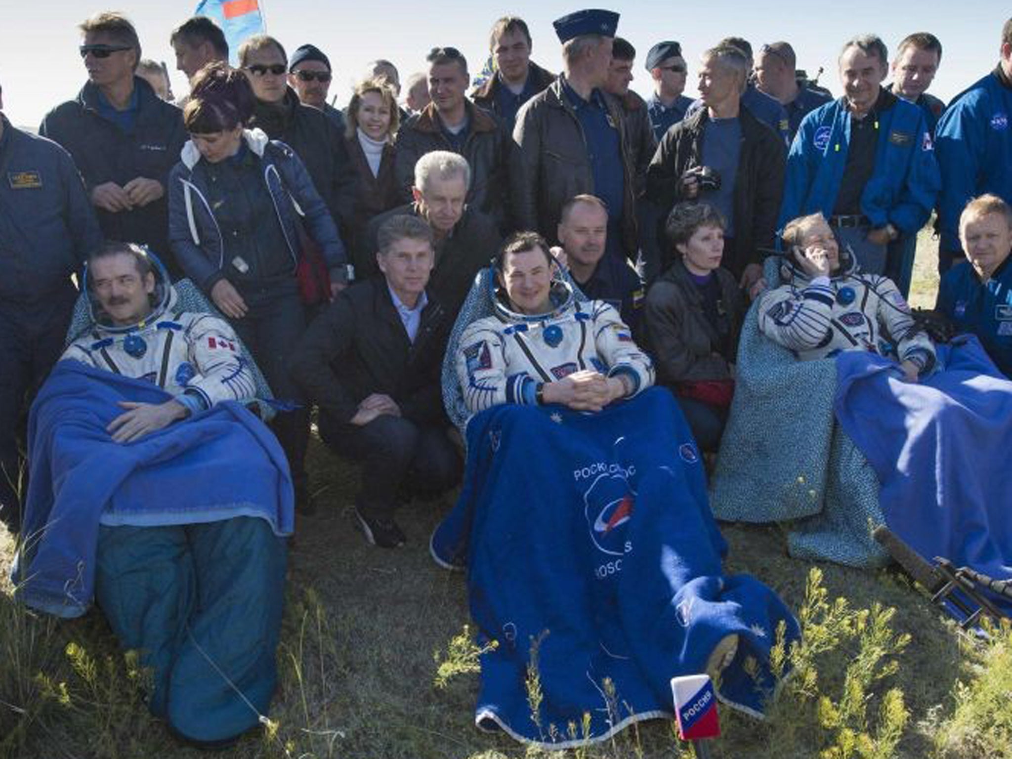 Left to right: Canadian astronaut Chris Hadfield, Russian cosmonaut Roman Romanenko and US astronaut Tom Marshburn sit after leaving the Russian Soyuz space capsule