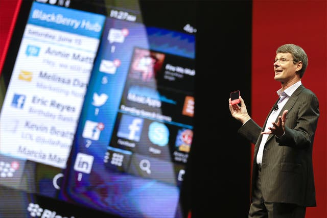 BlackBerry CEO Thorsten Heins holds up the new BlackBerry 10 at a conference in Florida on Tuesday
