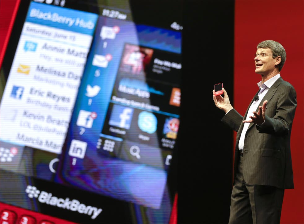 BlackBerry CEO Thorsten Heins holds up the new BlackBerry 10 at a conference in Florida on Tuesday