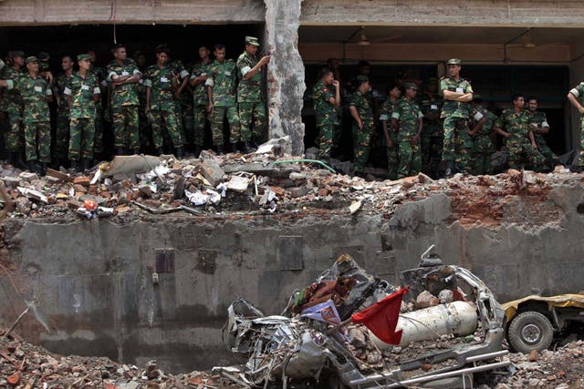 Bangladesh army soldiers stand at the wreckage of a Bangladeshi garment factory building to offer prayers for the souls of the 1,127 people who died in the structure's collapse last month (AP)