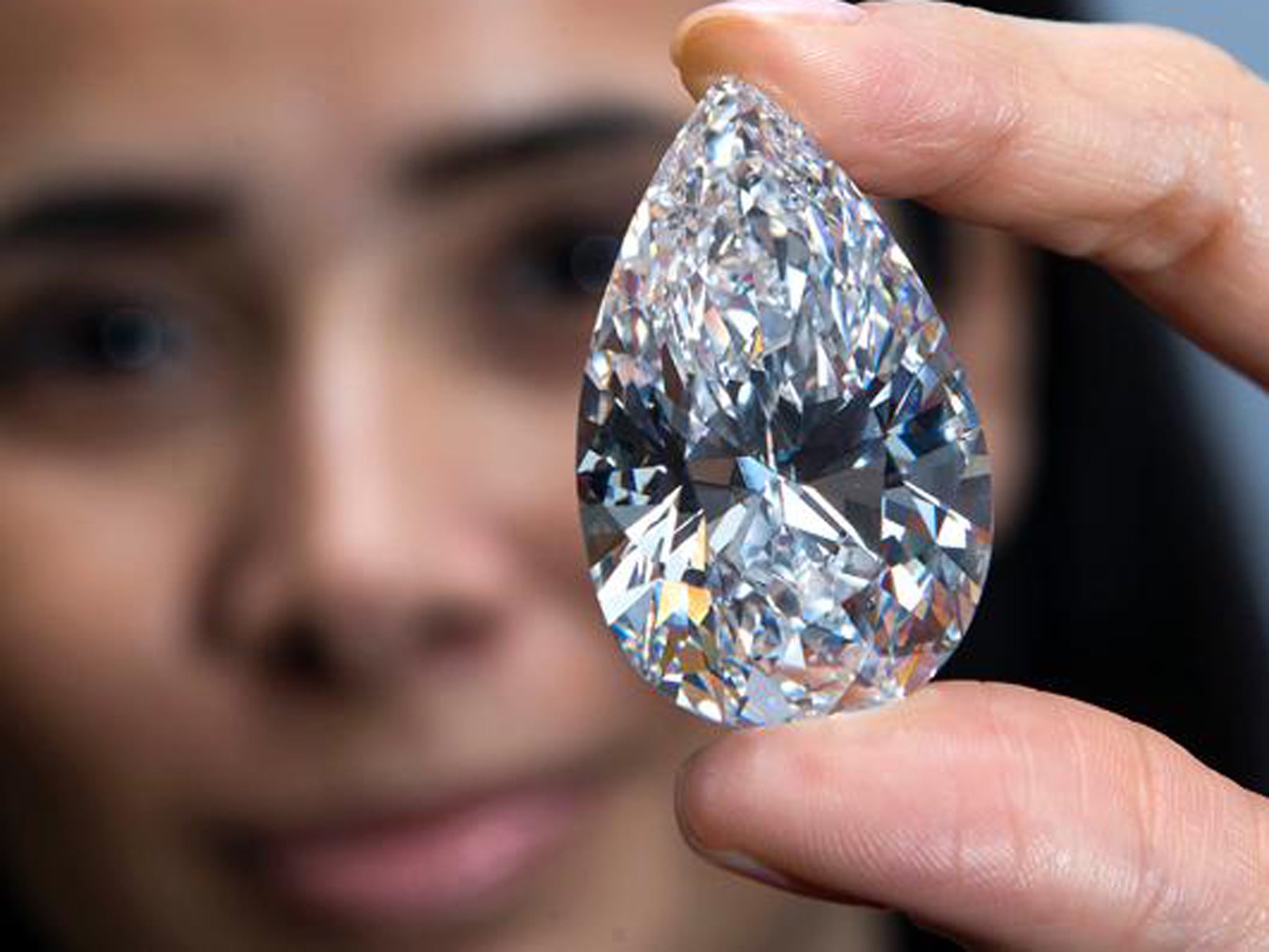An employee of Christie's auction house shows the 101.73-carat gem, at a preview ahead of the auction