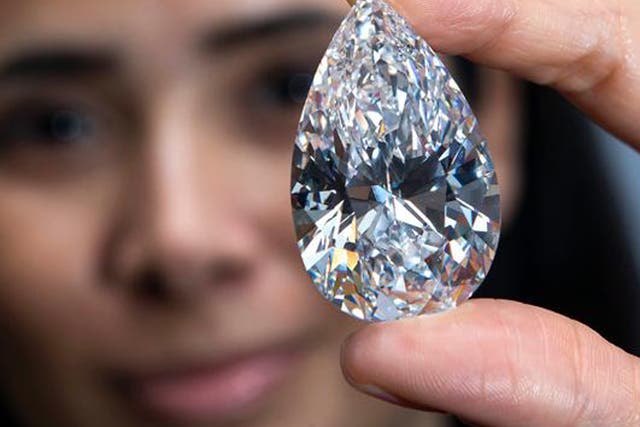 An employee of Christie's auction house shows the 101.73-carat gem, at a preview ahead of the auction