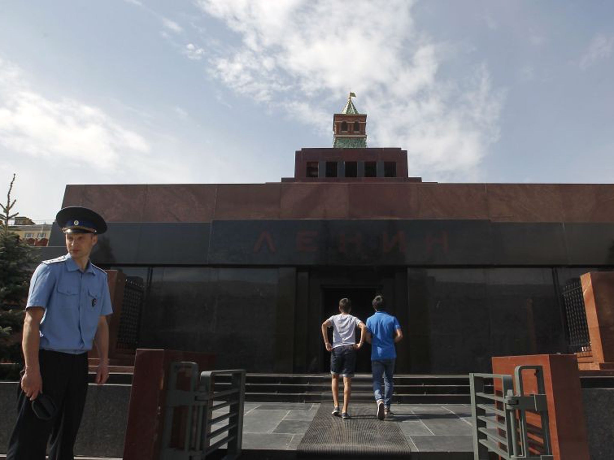 An Interior Ministry officer looks on as visitors enter the mausoleum of Soviet leader Vladimir Lenin