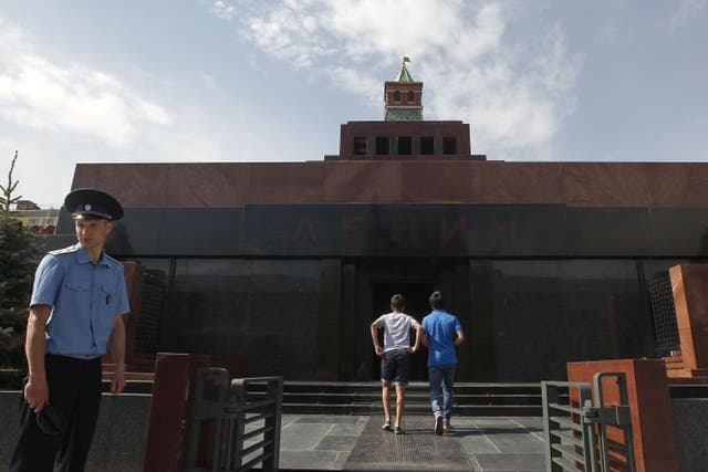 An Interior Ministry officer looks on as visitors enter the mausoleum of Soviet leader Vladimir Lenin