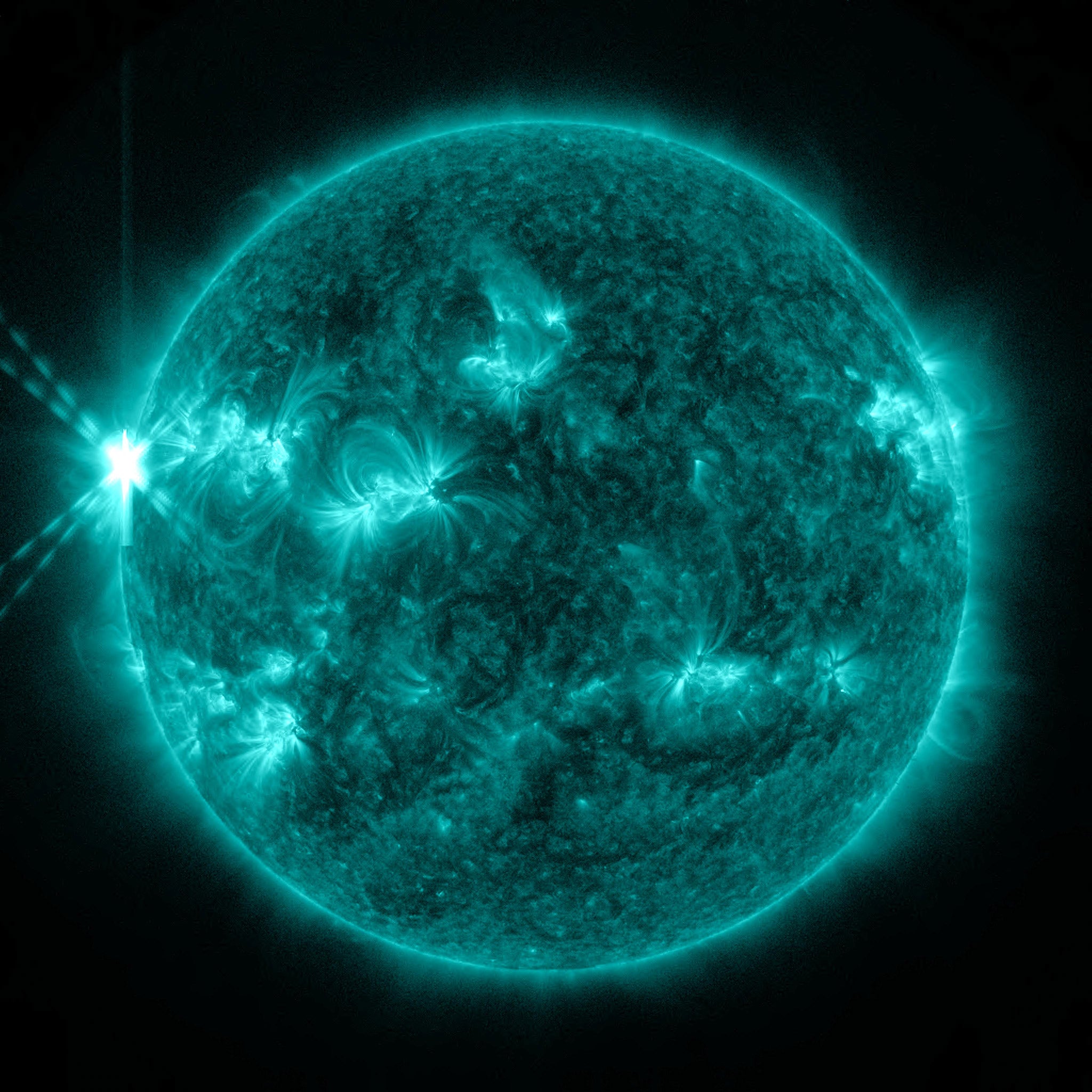 On May 13, 2013, an X2.8-class flare erupted from the sun - the strongest flare of 2013 to date. This image of the flare, shown in the upper left corner. It is typically colorized in teal