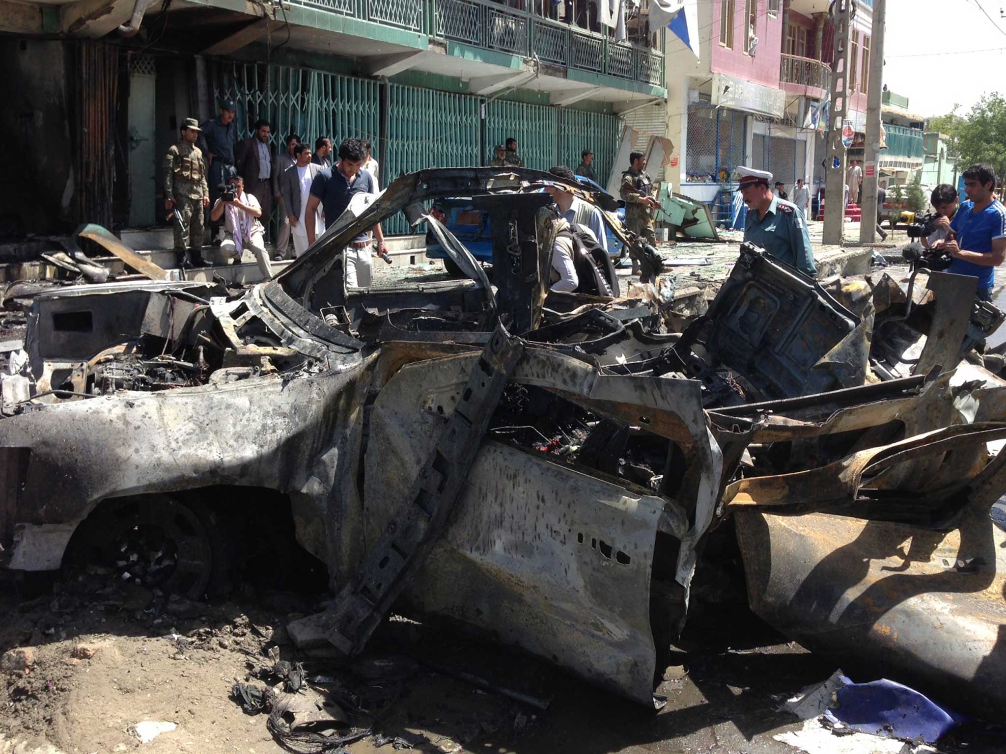 Afghan security and media representatives gather at the scene of the explosion in Kabul