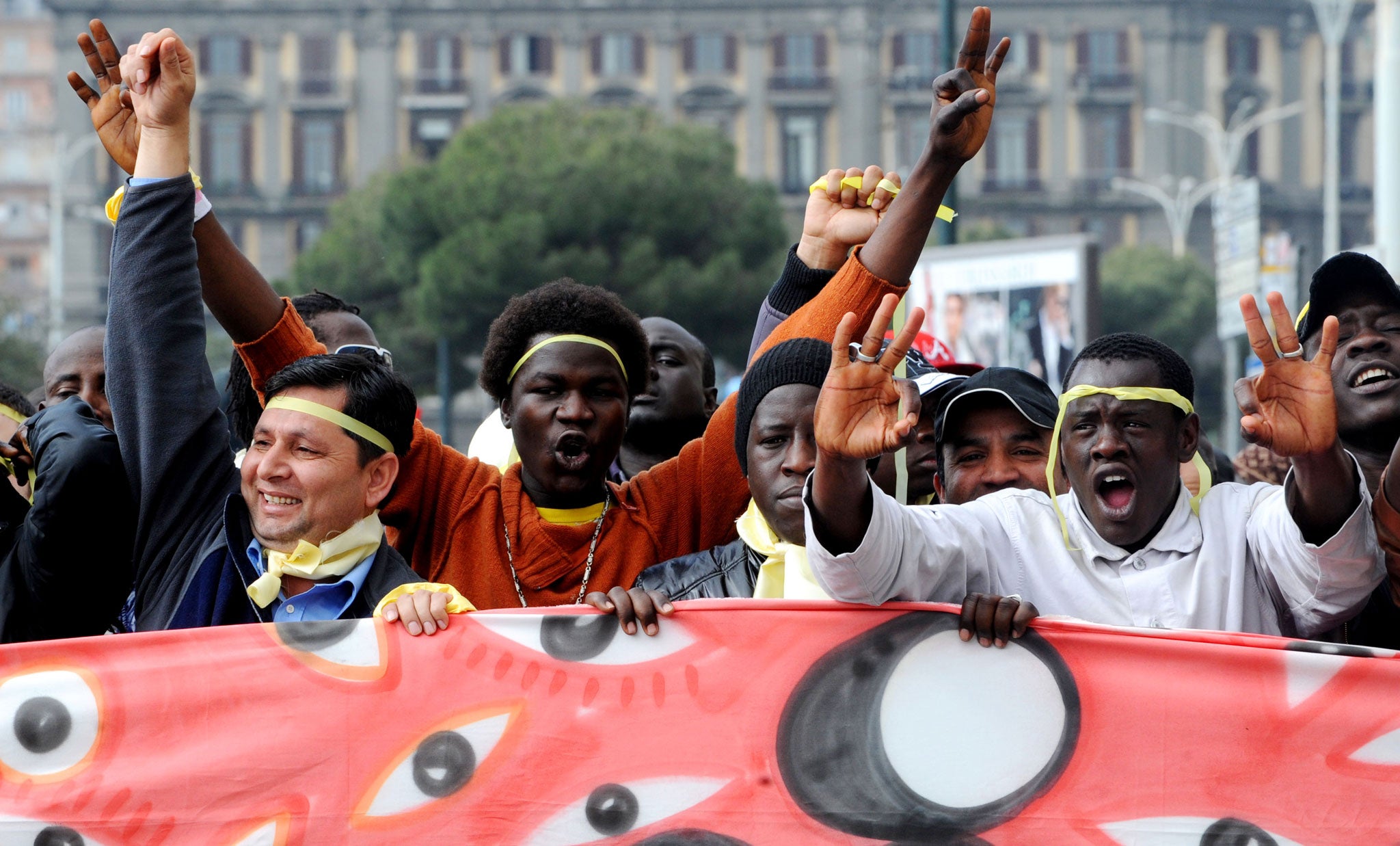 Kurdish and Cuban immigrants in Italy hold their national flags during the first Italian National Strike by immigrants in the country in Naples on March 1, 2010.