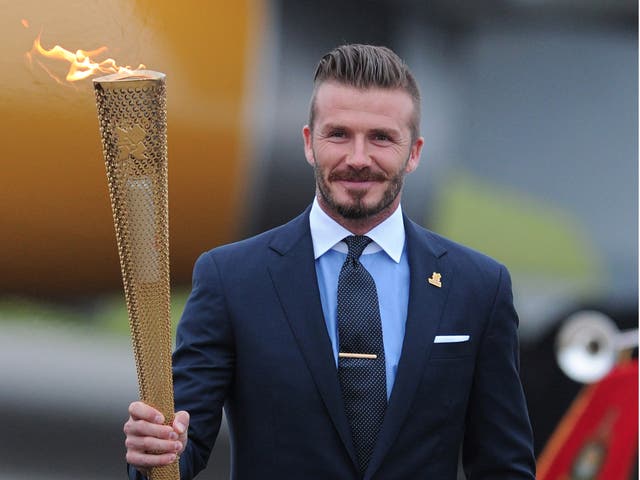 David Beckham holds the Olympic flame during the 2012 London Olympics, he was one of the key figures in the city's bid for the Games