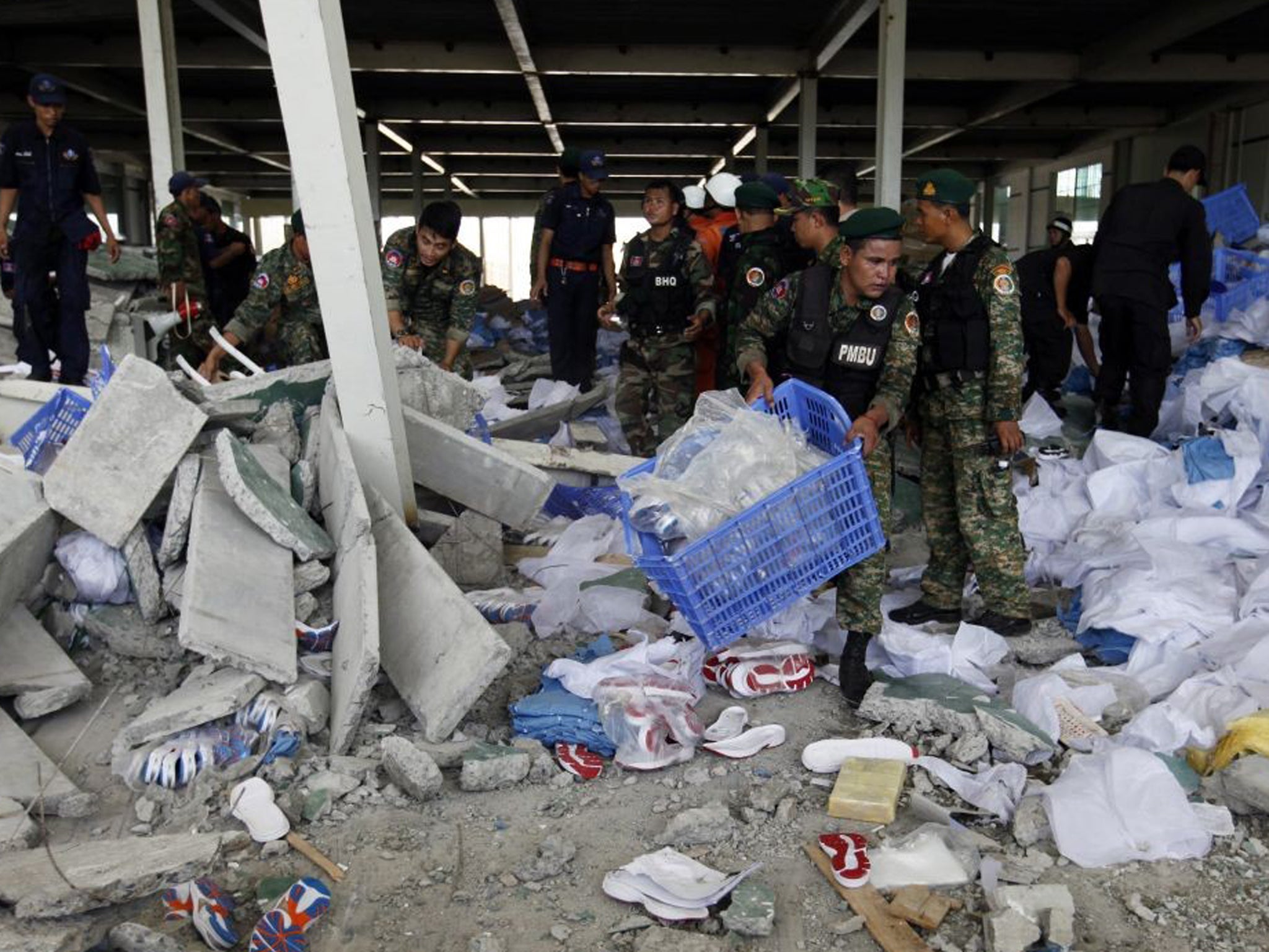 Cambodian officers search the wreckage after the factory collapse